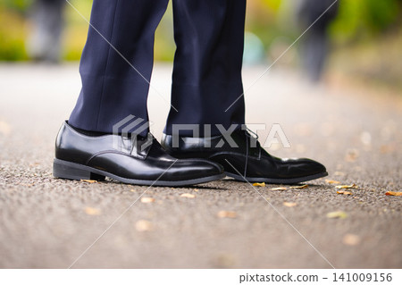 一位二十多歲的商人正在戶外散步。 一位二十多歲的商人正在戶外散步。 141009156