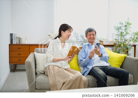 一對老年夫婦在沙發上放鬆休息。 141009206