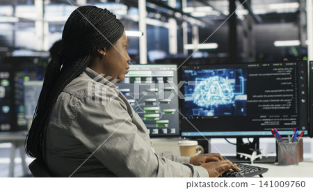 Server facility staff member rolling out AI solutions optimizing equipment. Server environment software engineer applying AI technology minimizing infrastructure downtime. Server facility staff member rolling out AI solutions optimizing equipment. Server environment software engineer applying AI technology minimizing infrastructure downtime. 141009760