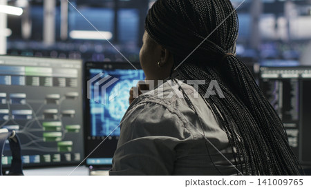 Server facility software engineer applying AI ML models to set up hardware. IT professional works on AI programming tools in server environment, optimizing system. Server facility software engineer applying AI ML models to set up hardware. IT professional works on AI programming tools in server environment, optimizing system. 141009765