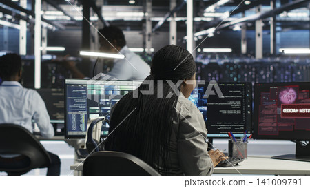 Data center coworkers react to unauthorized system access on a computer, securing server equipment and protecting confidential data. Data center coworkers react to unauthorized system access on a computer, securing server equipment and protecting confidential data. 141009791