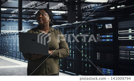 System administrator uses laptop in a server farm to plan disaster recovery and strengthen data protection. System administrator uses laptop in a server farm to plan disaster recovery and strengthen data protection. 141009794