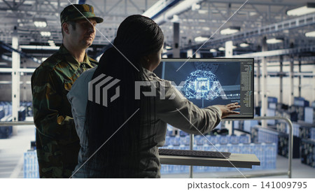 Military technology team reviews reconnaissance information with AI software in a server room environment. 141009795