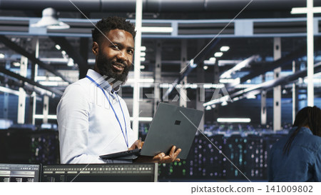 Data center administrator uses laptop node tree software to review analytics and identify equipment issues. Data center administrator uses laptop node tree software to review analytics and identify equipment issues. 141009802
