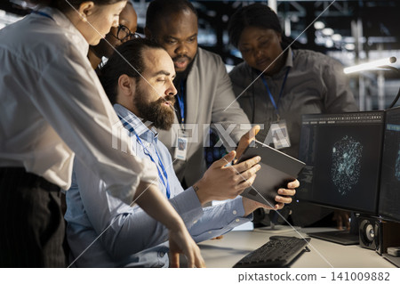 Team of software developers working with workstation in server environment, analyzing data. Team of software developers working with workstation in server environment, analyzing data. 141009882
