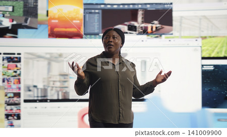 Person enjoys watching entertaining streaming media service media library on dynamic media wall. African American woman living entertainment focused digital age lifestyle. Person enjoys watching entertaining streaming media service media library on dynamic media wall. African American woman living entertainment focused digital age lifestyle. 141009900