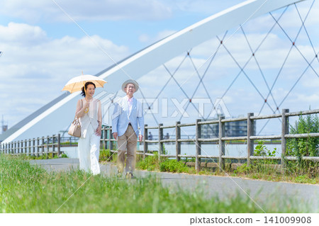Parents and children walking along the riverbank; elderly people; middle-aged and older people 141009908