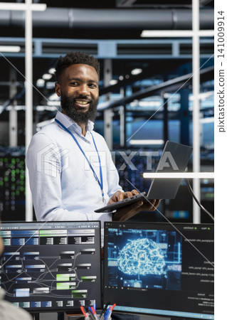 Pleased data center professional celebrates after configuring machine learning systems with AI technology in a data center. Pleased data center professional celebrates after configuring machine learning systems with AI technology in a data center. 141009914