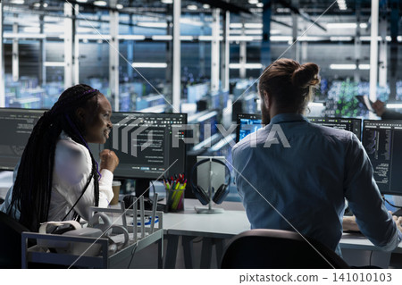 Data center team works together on diagnostics, maintenance tasks and server equipment performance checks. 141010103