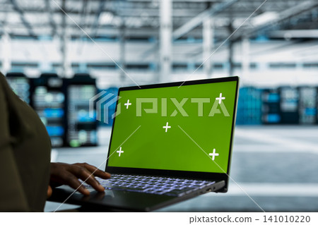 Data center administrator works with a chroma key laptop, using an editable screen to review performance data. Data center administrator works with a chroma key laptop, using an editable screen to review performance data. 141010220