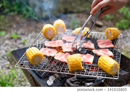 Grilled meat and corn over charcoal 141010805