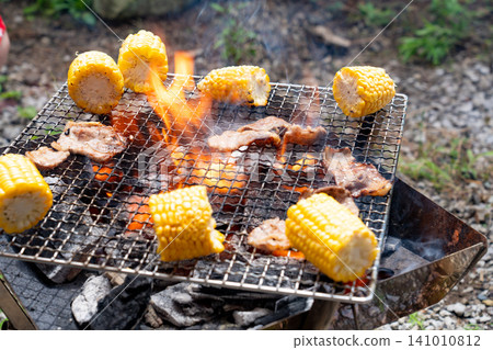 Meat and corn grilled over a flame Meat and corn grilled over a flame 141010812