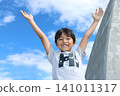 A Japanese elementary school child with arms outstretched and a happy smile. 141011317