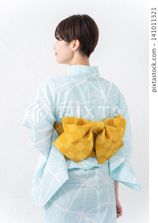 A full-body view of a woman wearing a yukata, from behind. A full-body view of a woman wearing a yukata, from behind. 141011321