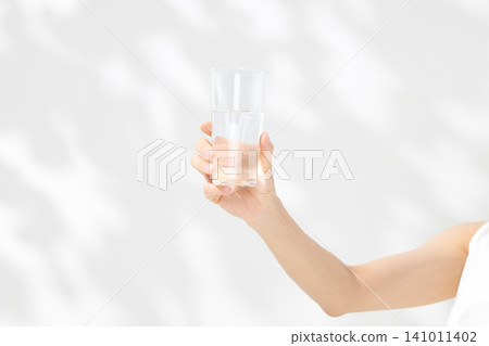 一隻女人的手拿著一杯水 141011402