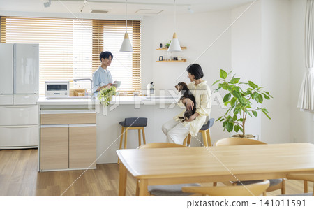 與狗狗相伴的生活畫面:一對三十多歲的男女在家中與一隻迷你臘腸犬放鬆身心。 與狗狗相伴的生活畫面:一對三十多歲的男女在家中與一隻迷你臘腸犬放鬆身心。 141011591