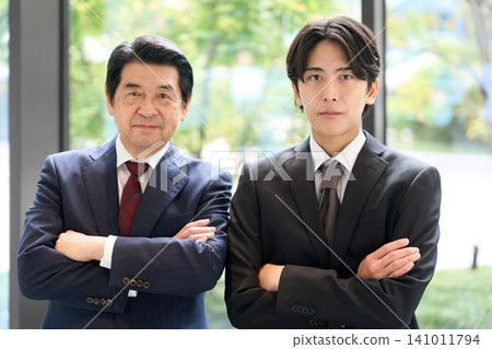 An Asian businessperson standing with his arms crossed. An Asian businessperson standing with his arms crossed. 141011794