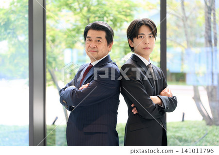 An Asian businessperson standing with his arms crossed. An Asian businessperson standing with his arms crossed. 141011796