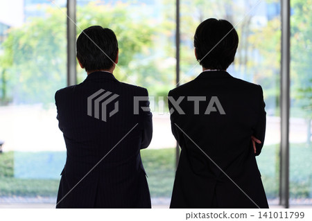 一位商務人士背對著鏡頭，望向窗外。 141011799