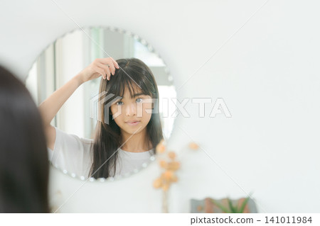 小學生女生們正在為她們的髮型而煩惱 小學生女生們正在為她們的髮型而煩惱 141011984