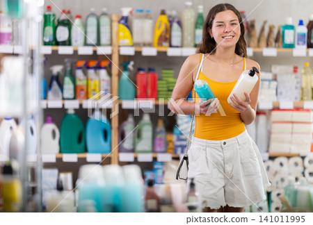 Young woman examining shampoo bottles in personal care store Young woman examining shampoo bottles in personal care store 141011995