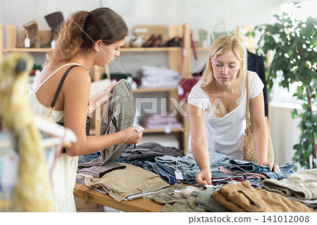Two women choosing pants in a store 141012008