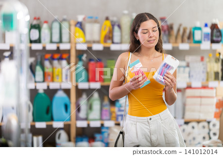 Young woman choosing razors in personal care store Young woman choosing razors in personal care store 141012014