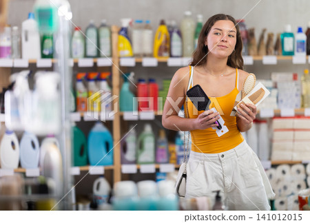 Young girl choosing comb in store in hot season 141012015