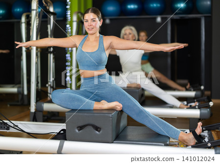 Woman doing bends on a reformer 141012024