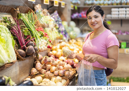 Woman shopping, examine vegetable in store and buy elect onion. 141012027