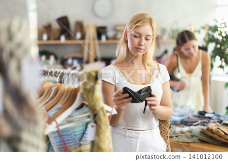 Young woman with her friend choosing high heels in store 141012100
