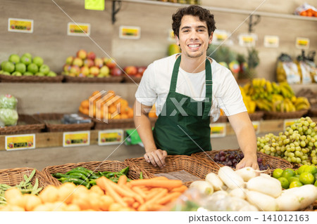 Man worker seller in grocery vegetable shop assort fruit daicon radish Man worker seller in grocery vegetable shop assort fruit daicon radish 141012163