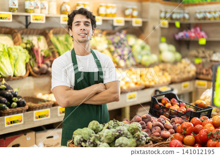 Portrait of successful male salesperson wearing an apron in grocery store interior Portrait of successful male salesperson wearing an apron in grocery store interior 141012195