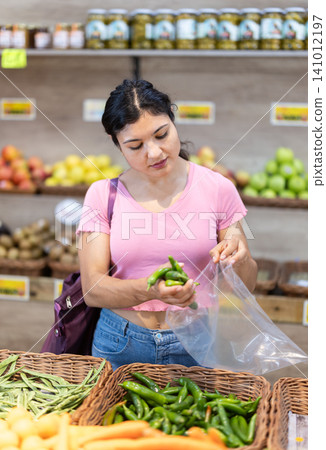 Woman shopping, examine vegetable in store and buy elect pepper. Woman shopping, examine vegetable in store and buy elect pepper. 141012197