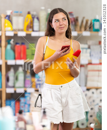 Young woman scanning barcode on repellent in supermarket Young woman scanning barcode on repellent in supermarket 141012328