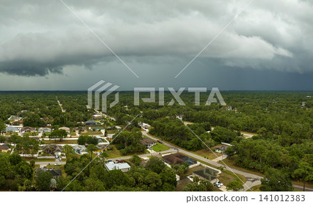 Landscape of dark ominous clouds forming on stormy sky before heavy thunderstorm over rural town area Landscape of dark ominous clouds forming on stormy sky before heavy thunderstorm over rural town area 141012383