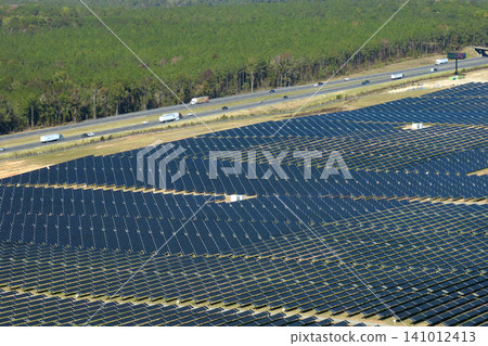 Aerial view of big sustainable electric power plant with many rows of solar photovoltaic panels for producing clean electrical energy. Renewable electricity with zero emission concept Aerial view of big sustainable electric power plant with many rows of solar photovoltaic panels for producing clean electrical energy. Renewable electricity with zero emission concept 141012413