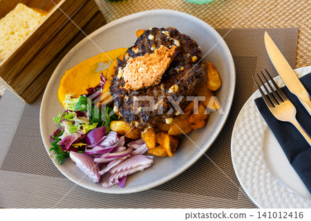 Pleskavitsa is fried minced cutlet with vegetable garnish Pleskavitsa is fried minced cutlet with vegetable garnish 141012416
