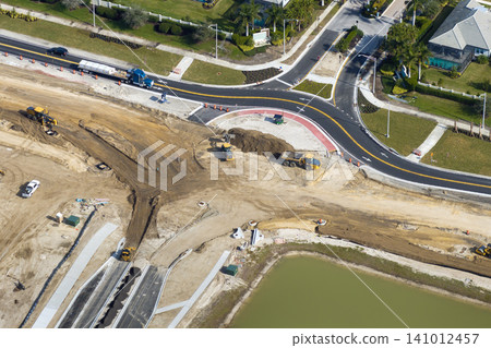 Industrial construction roadworks at roundabout intersection with moving cars in Venice, Florida. Development of urban circular transportation crossroads 141012457