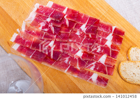Sliced cured ham is served on board Sliced cured ham is served on board 141012458