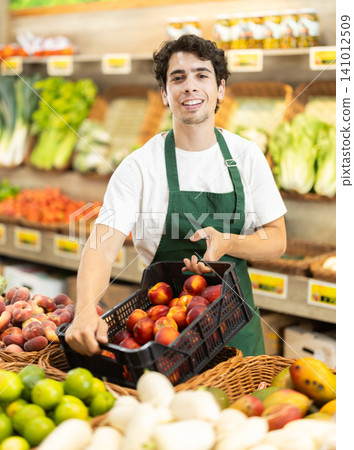 Man worker seller in grocery vegetable shop and plum 141012509