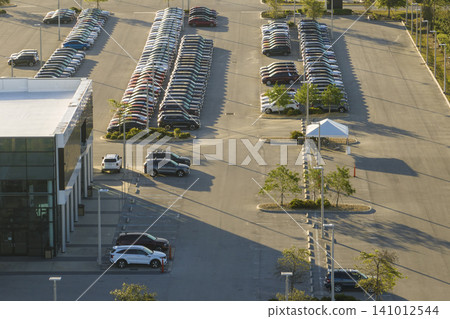 Large parking lot of local dealer with many brand new cars parked for sale. Development of american automotive industry and distribution of manufactured vehicles concept Large parking lot of local dealer with many brand new cars parked for sale. Development of american automotive industry and distribution of manufactured vehicles concept 141012544