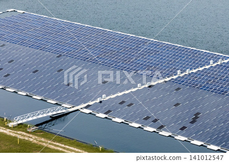 Generation of renewable electricity on water surface with no air pollution. Industrial pond with floating photovoltaic solar panels for producing clean electrical energy Generation of renewable electricity on water surface with no air pollution. Industrial pond with floating photovoltaic solar panels for producing clean electrical energy 141012547