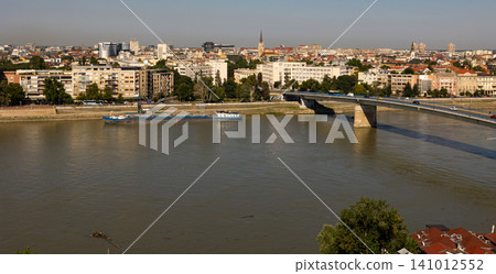 Captivating panorama of Novi Sad. Serbia. Where the majestic Danube River flows beneath picturesque skyline Captivating panorama of Novi Sad. Serbia. Where the majestic Danube River flows beneath picturesque skyline 141012552