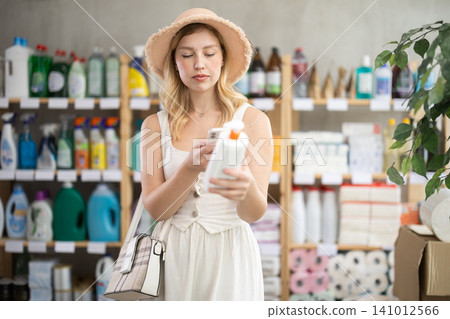 Girl buyer scans qr code on sunblock cream label Girl buyer scans qr code on sunblock cream label 141012566