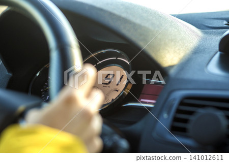 Modern car interior with driver hand on steering wheel. Safe driving concept. 141012611
