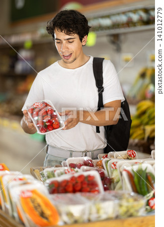 Male customer choosing vegetables and fruits in packaging at grocery store Male customer choosing vegetables and fruits in packaging at grocery store 141012779
