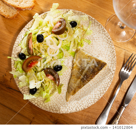Tasty salad with cod and fresh herbs - lettuce leaves and tomatoes 141012804