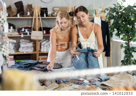 Two women choosing high-quality jeans in the store 141012833