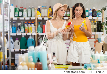 Two friends girls view trademark sign on label, pick eco friendly insect repellent Two friends girls view trademark sign on label, pick eco friendly insect repellent 141012834